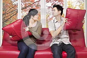 Couple quarreling and throwing pillow