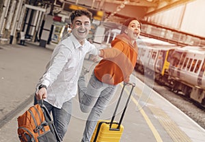 couple at railway station waiting for the train. Woman and man running to board a train