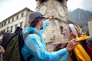 Couple  in  raincoat  walks through the old city streets on rainy day