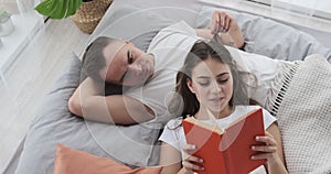 Couple reading book in bed