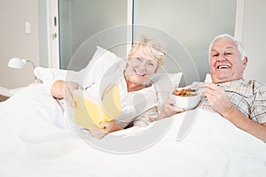 Couple reading book in bed at home