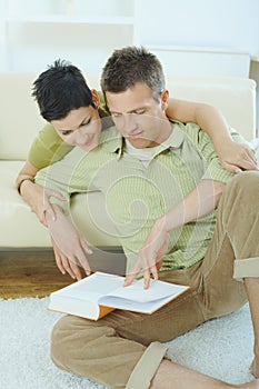 Couple reading book at home