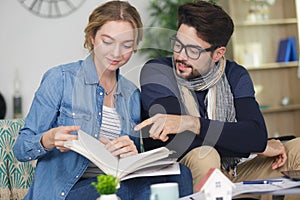 couple reading book on sofa couch