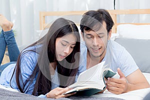 Couple reading a book together in bedroom on the morning.