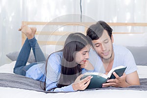 Couple reading a book together in bedroom on the morning.