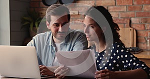 Couple reading document discuss agreement details at home