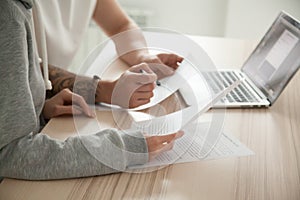 Couple holding reading documents at home with laptop, close up photo