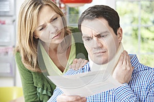 Couple Reading Letter In Respect Of Husband's Neck Injury