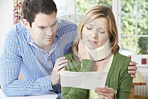 Couple Reading Letter In Respect Of Wife's Neck Injury