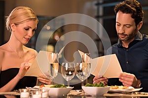 Couple reading menu at restaurant photo