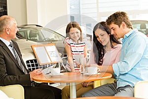 Couple reading papers in car dealership