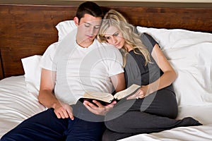 Couple reads the Bible in bed