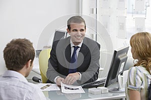 Couple With Real Estate Agent In Office