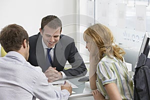 Couple With Real Estate Agent In Office