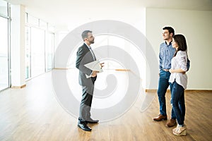 Couple With Real Estate Agent Visiting New House