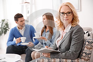 Couple at real estate sales office with agent writing in organizer