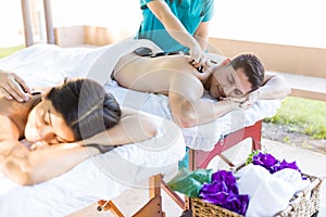 Couple Receiving Soothing Massage From Masseuses