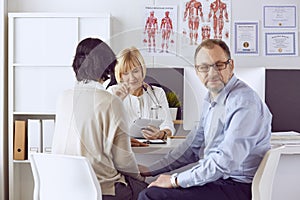 Couple at reception discussing issues with a sexologist photo