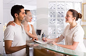 Couple with receptionist at clinic