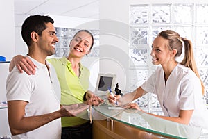 Couple with receptionist at clinic