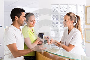 Couple with receptionist at clinic