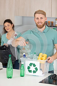 couple recycling empty plastic bottles