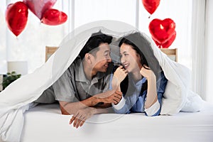 Couple with red rose flower, lovely couple lying in a bed, happy smile kissing, concept of valentine day