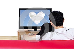 Couple on red sofa watching love cloud on tv