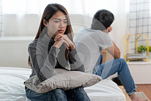 couple relationship problems. Sad young wife sitting on the bed back to back from husband after argument