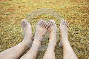 Couple Relax barefoot happy nature lawn on the grass in brown tone