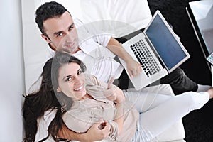 Couple relax and work on laptop computer at home