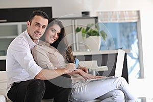 Couple relax and work on laptop computer at home