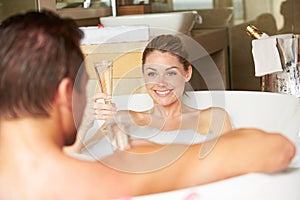 Couple Relaxing In Bath Drinking Champagne Together