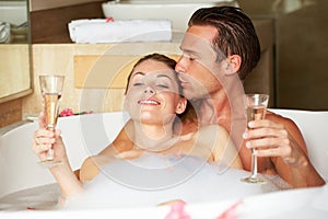 Couple Relaxing In Bath Drinking Champagne Together