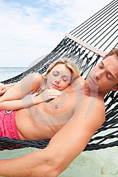 Couple Relaxing In Beach Hammock