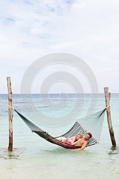 Couple Relaxing In Beach Hammock