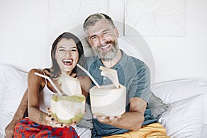 Couple relaxing on the bed drinking coconut