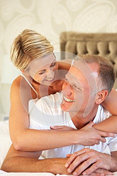 Couple Relaxing In Bedroom