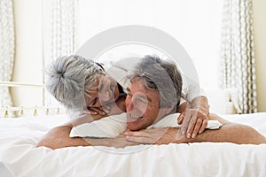 Couple relaxing in bedroom and smiling