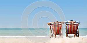 Couple relaxing on chair beach over sea background