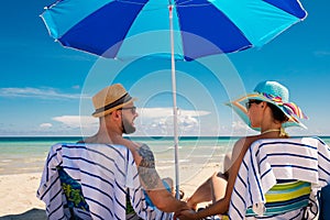 Couple relaxing on a deck chairs on a beach