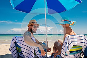 Couple relaxing on a deck chairs on a beach