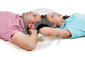 Couple relaxing on floor with hands on their heads