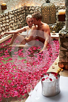 Couple Relaxing In Flower Petal Covered Pool