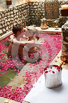 Couple Relaxing In Flower Petal Covered Pool