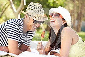 Couple Relaxing In Garden Eating Ice Lolly