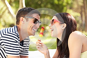 Couple Relaxing In Garden Eating Lolly