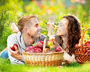 Couple Relaxing on the Grass and Eating Apples