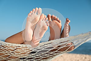 Couple relaxing in hammock on beach