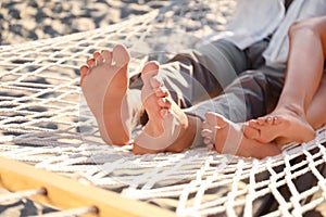 Couple relaxing in hammock on beach, closeup